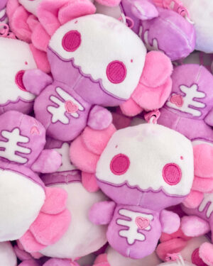 Pile of pink and white plush stuffed animals with heart motifs and embroidered eyes.