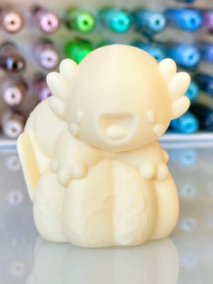 Close-up of a cream-colored cartoon toy with rounded spikes around its head, against a blurred colorful background.